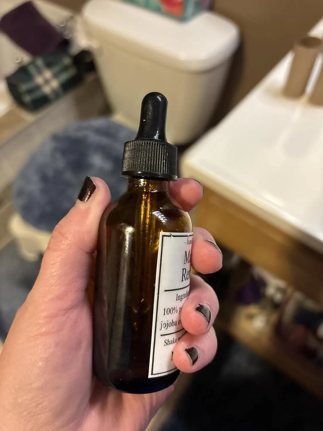 Customer photo of amber glass dropper bottle with jojoba oil label in bathroom