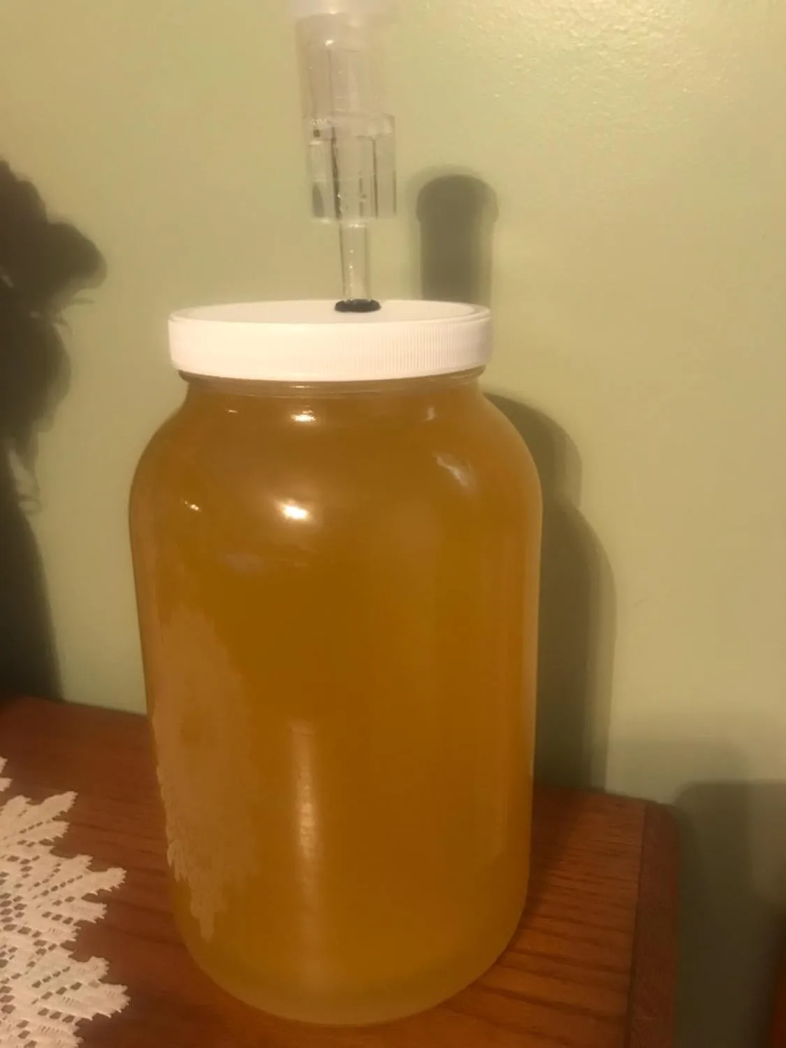 Customer photo of glass fermentation jar filled with amber-colored liquid and airlock lid