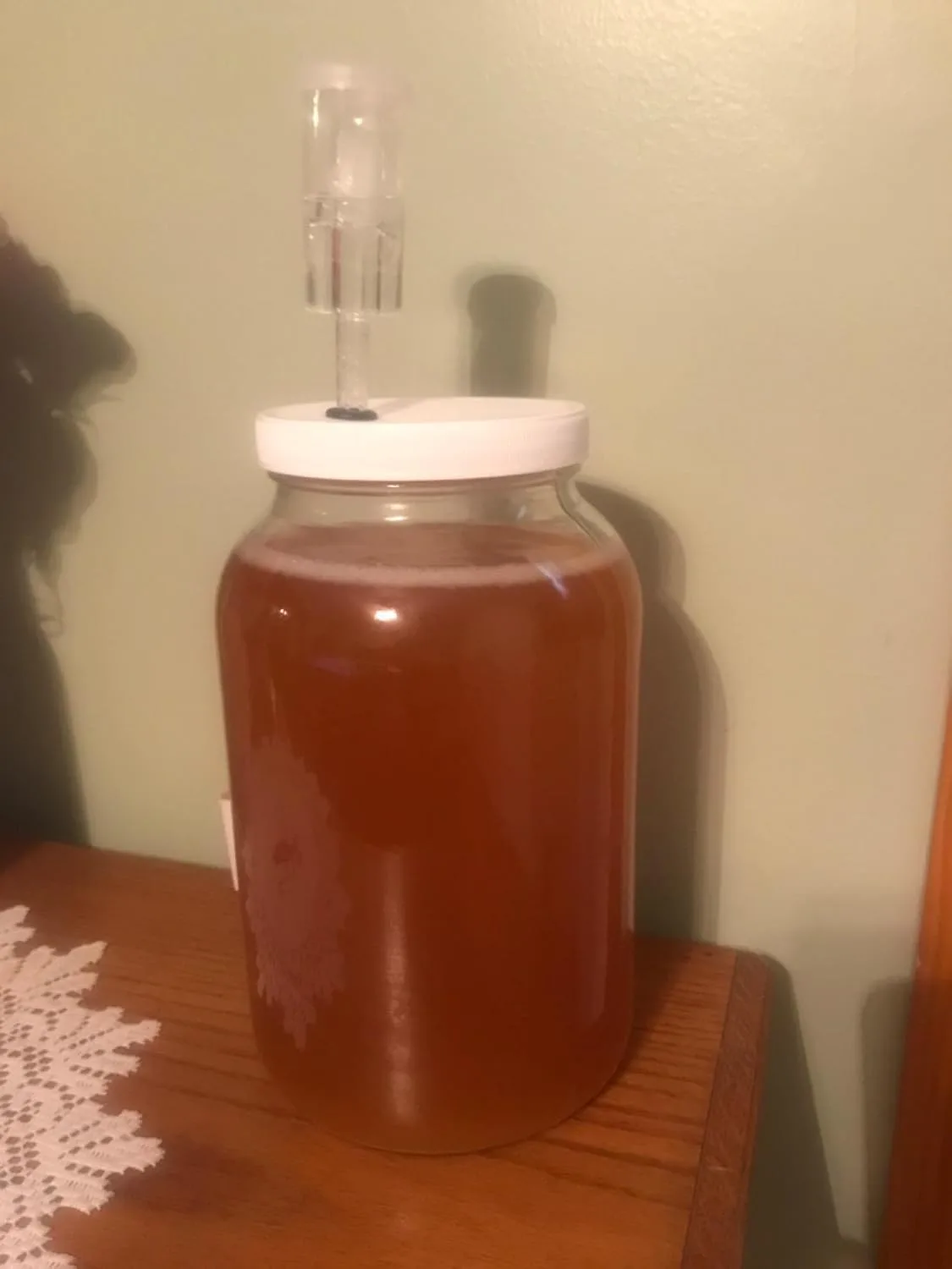 Customer photo of glass fermentation jar filled with dark red liquid on wooden table