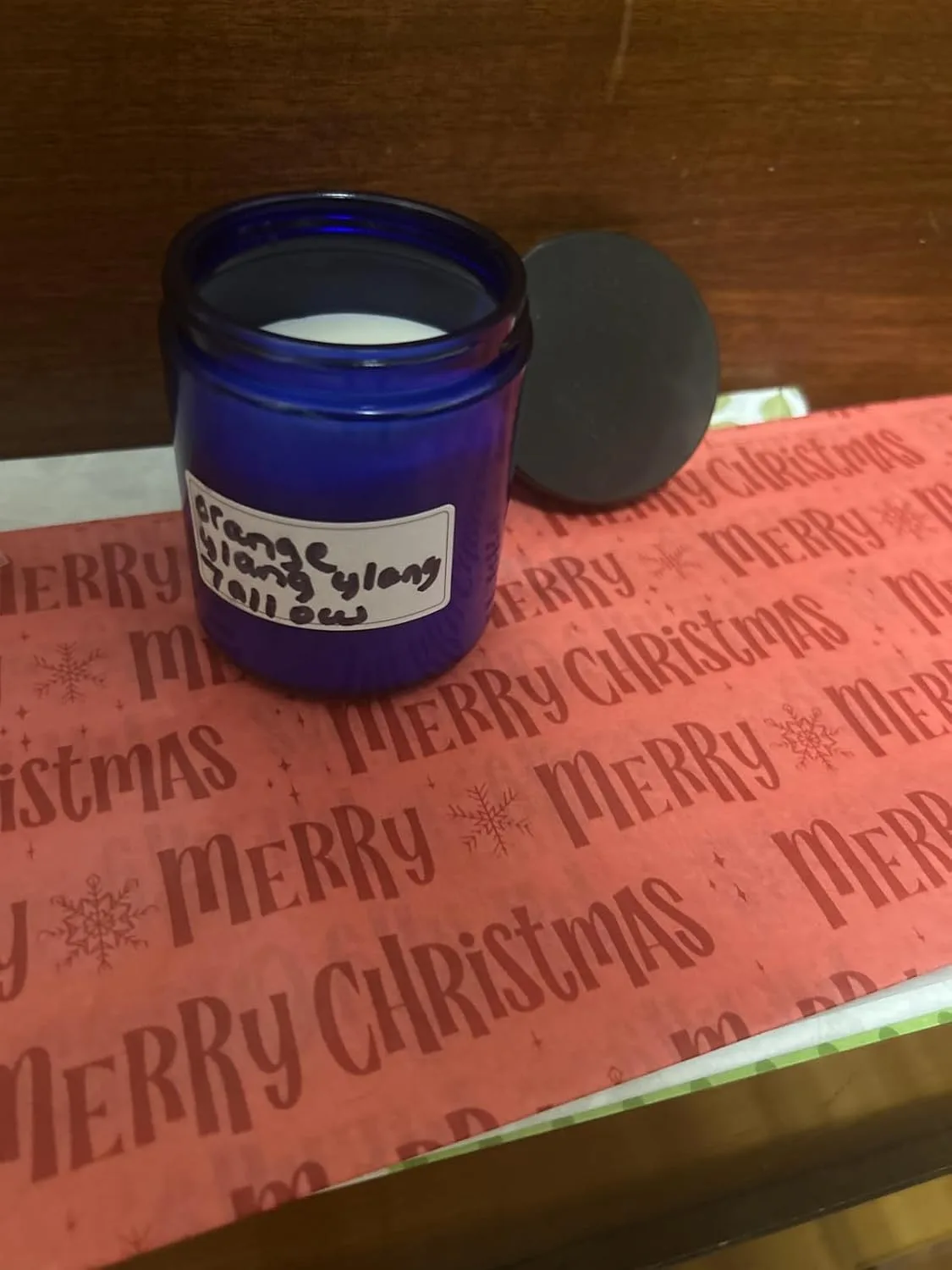 Customer photo of blue glass jar with handwritten label on red Christmas wrapping paper