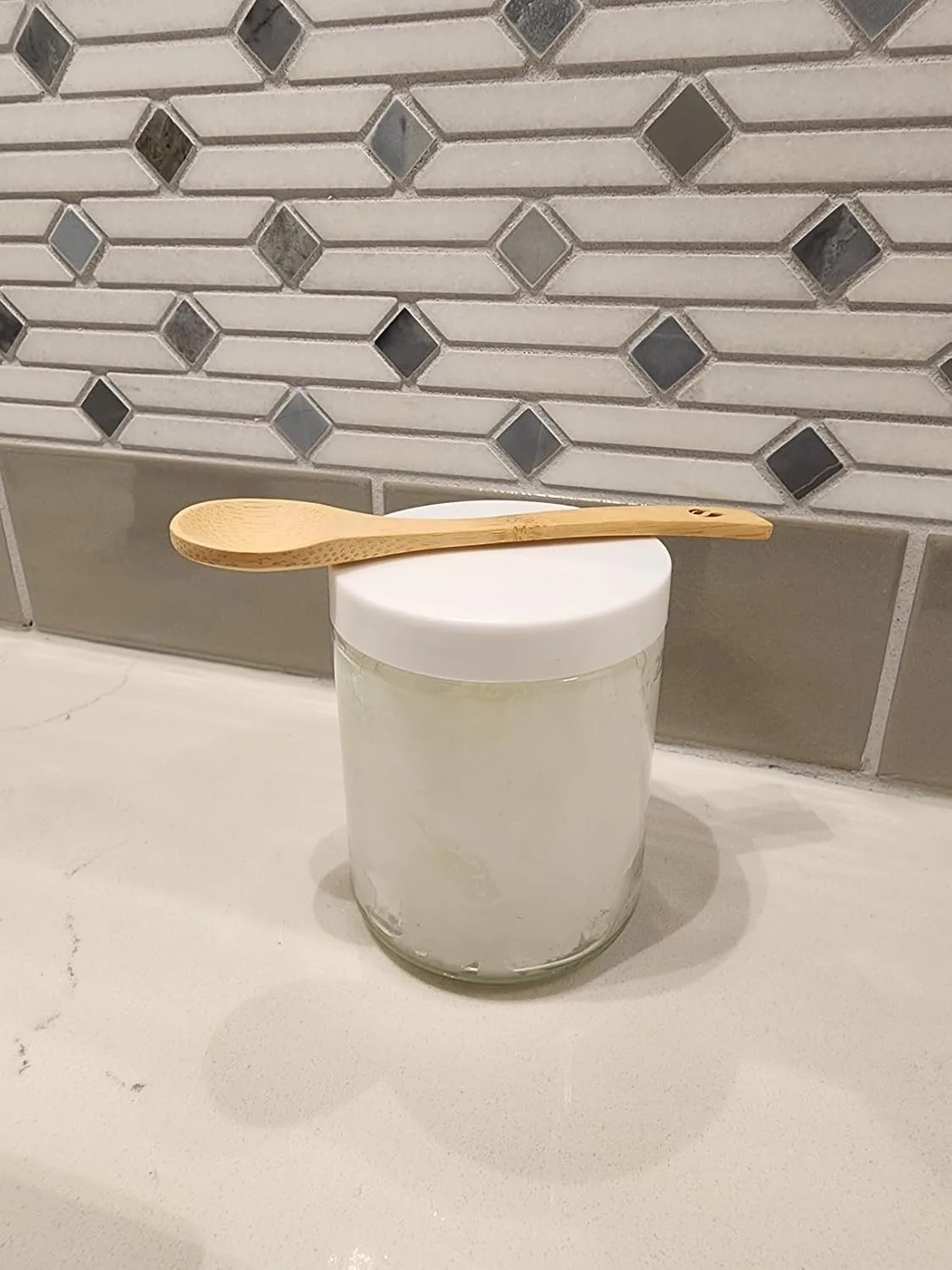 Customer photo of glass jar with white lid and wooden spoon on kitchen counter